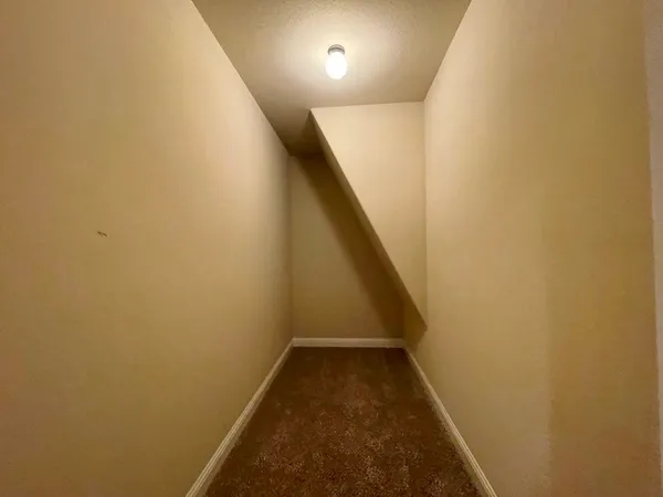 a view of an empty room with a ceiling fan and window