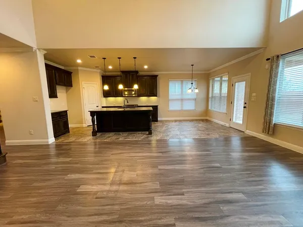 a view of a living room with kitchen view and wooden floor