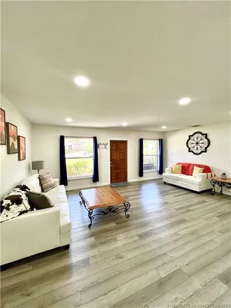 a living room with furniture window and dresser