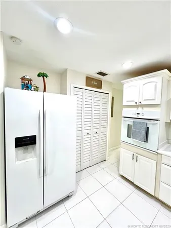 a kitchen with white cabinets and white appliances