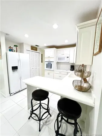a kitchen with stainless steel appliances a table and chairs in it