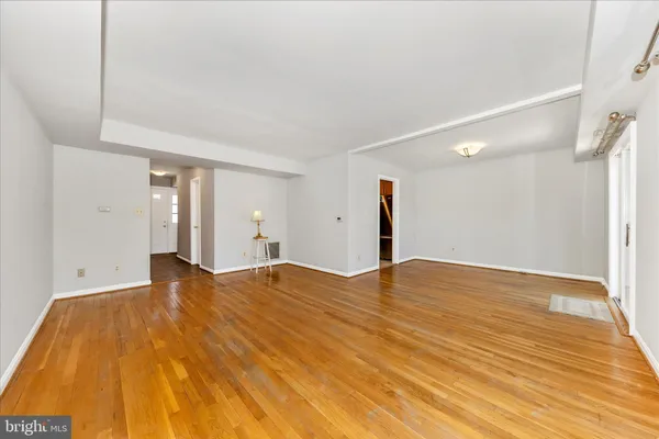 a view of empty room with wooden floor
