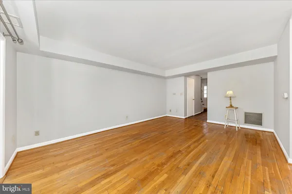 a view of empty room with wooden floor