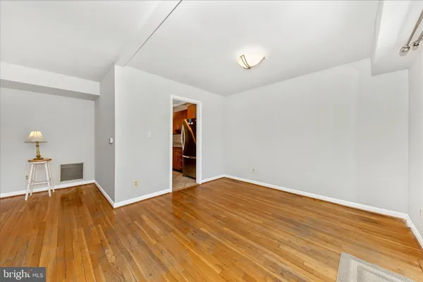 a view of empty room with wooden floor