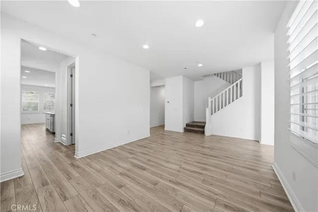 an empty room with wooden floor and fireplace