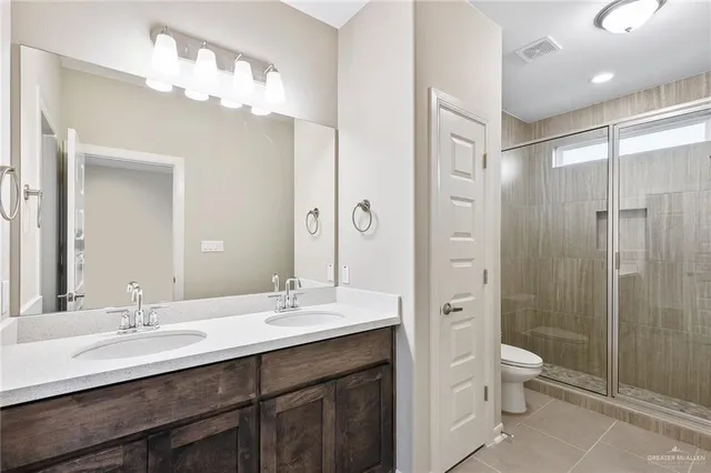 a bathroom with a double vanity sink mirror double and a shower