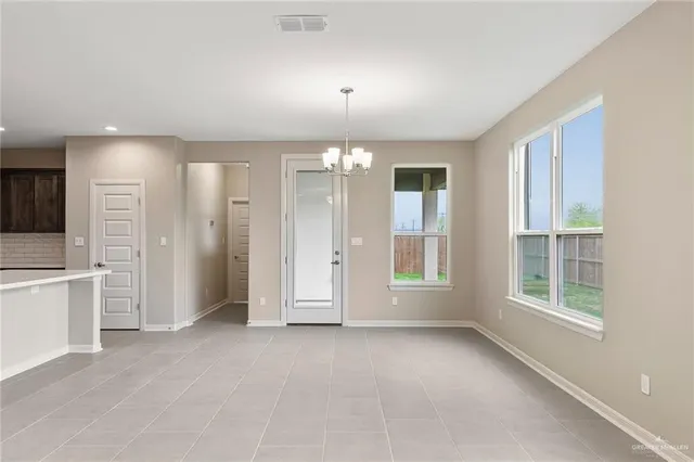 an empty room with windows and refrigerator
