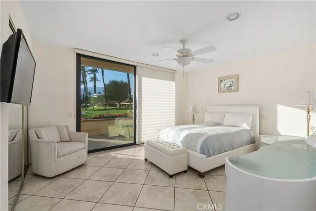 a bedroom with a large bed and a flat tv screen