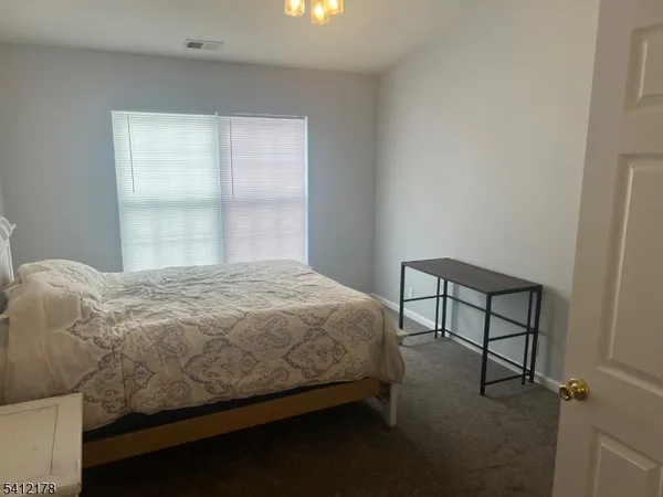 a bedroom with a bed window and a table in it
