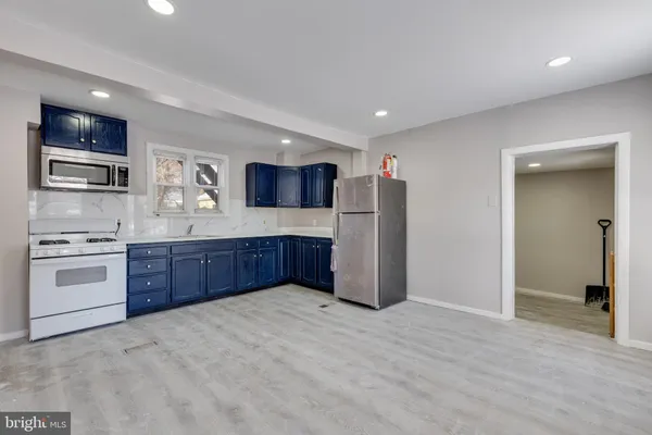 a large kitchen with stainless steel appliances granite countertop a refrigerator and a stove top oven