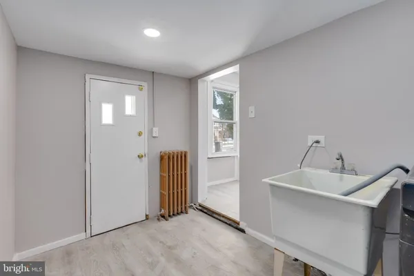a view of a hallway to a room with wooden floor