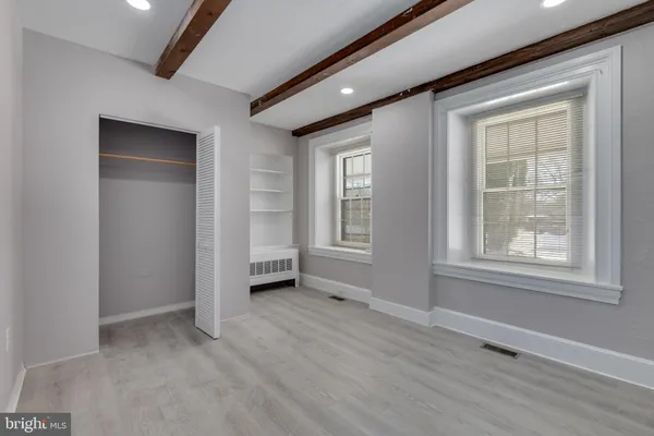 an empty room with windows and closet