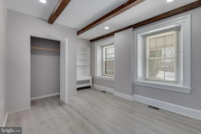 an empty room with windows and closet