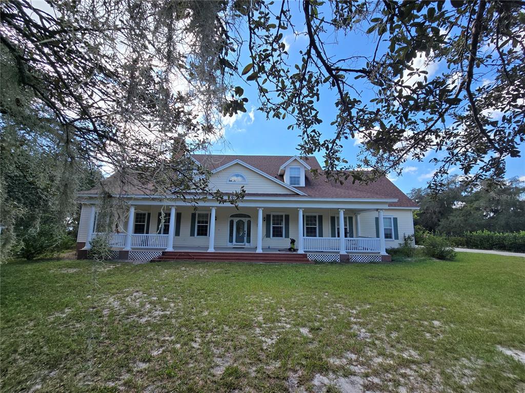 11940 Kirby Smith Road Orlando, FL 32832 - Photo 1 of 1 a front view of a house with a garden and trees