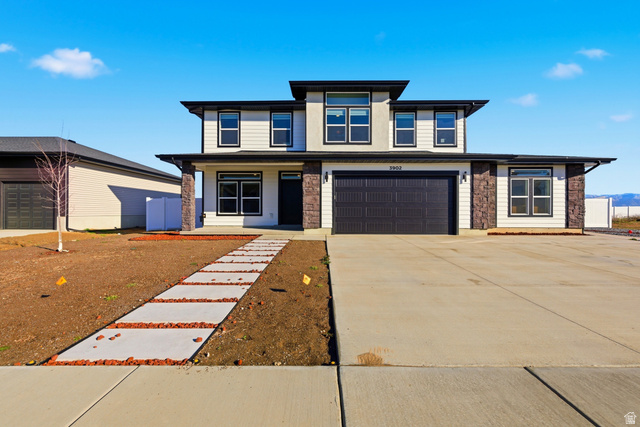 3902 West 825 North West Point, UT 84015 - Photo 2 of 49 Prairie-style house featuring a porch, concrete driveway, a garage, and stone siding
