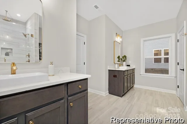 a spacious bathroom with a sink double vanity granite tub shower and a mirror