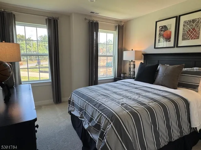 a bedroom with a bed a dresser next to a window