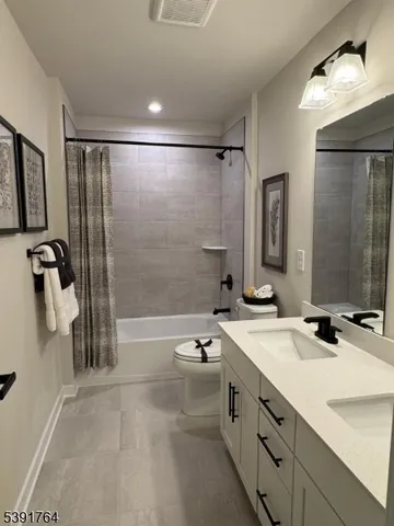 a bathroom with a granite countertop sink a toilet and shower