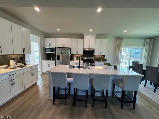 a kitchen with a dining table chairs and wooden floor