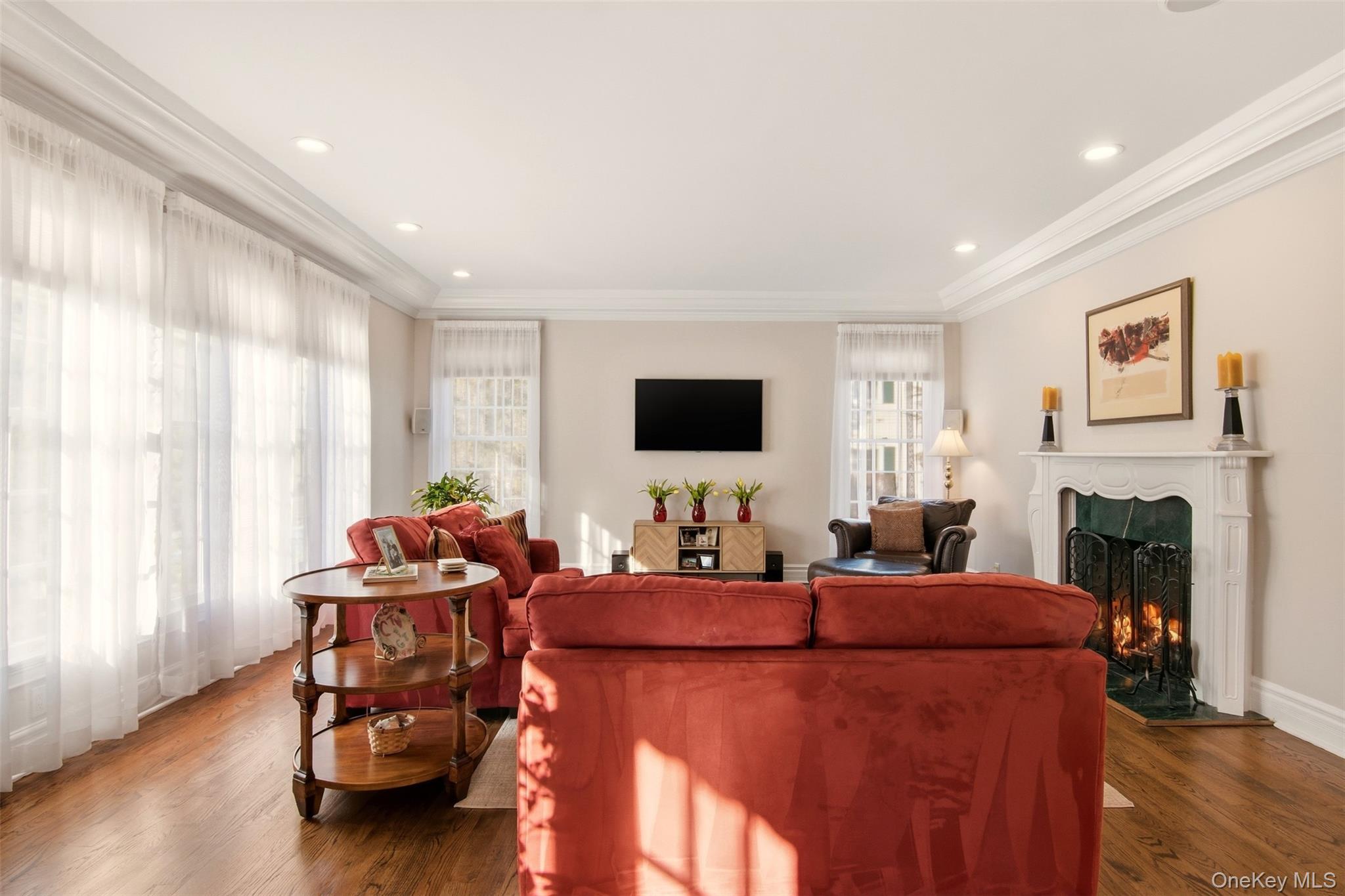 4 Daniel Way Setauket, NY 11733 - Photo 14 of 50 a living room with furniture a fireplace and a flat screen tv