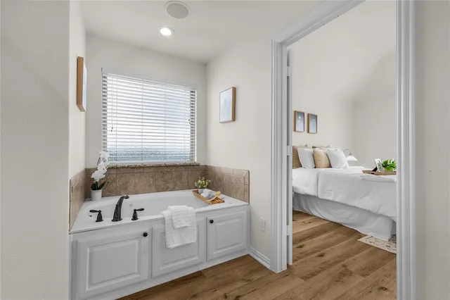 a en suite bathroom with a tub sink and mirror