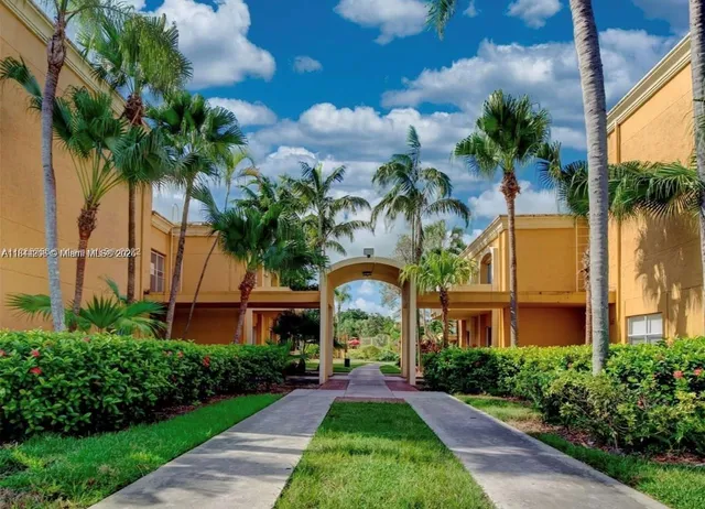 a front view of multi story residential apartment building with yard and green space