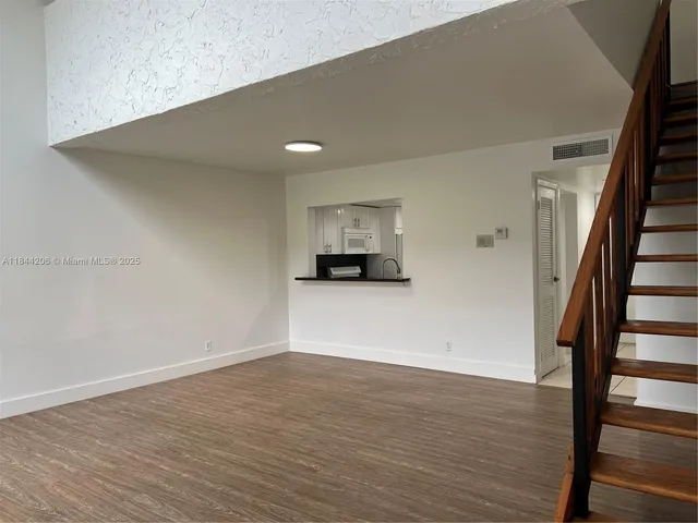 a view of a room with wooden floor and stairs