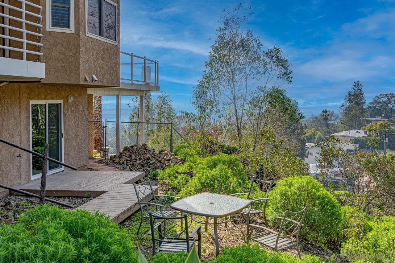 a view of a chair and table in backyard of the house