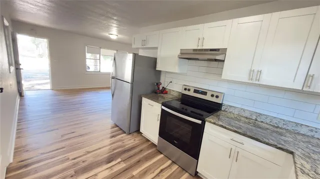 a kitchen with white cabinets and white stainless steel appliances