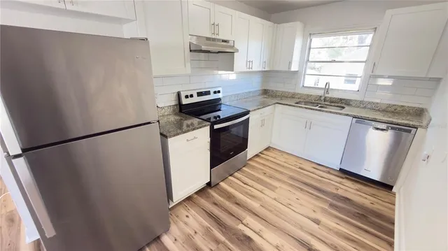 a bathroom with a sink a toilet a mirror and shower