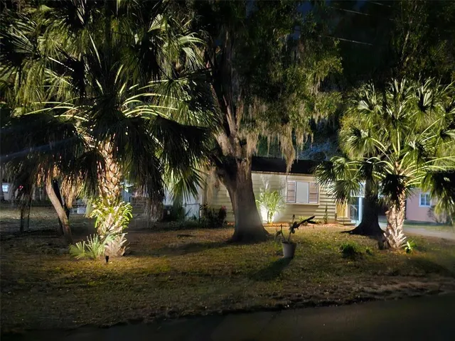 a view of a house with a yard and tree s