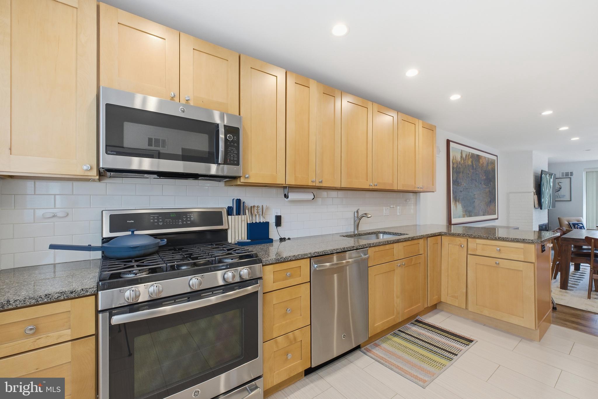 4848 Reservoir Road Northwest Washington, DC 20007 - Photo 12 of 49 a kitchen with stainless steel appliances granite countertop a stove sink microwave and cabinets