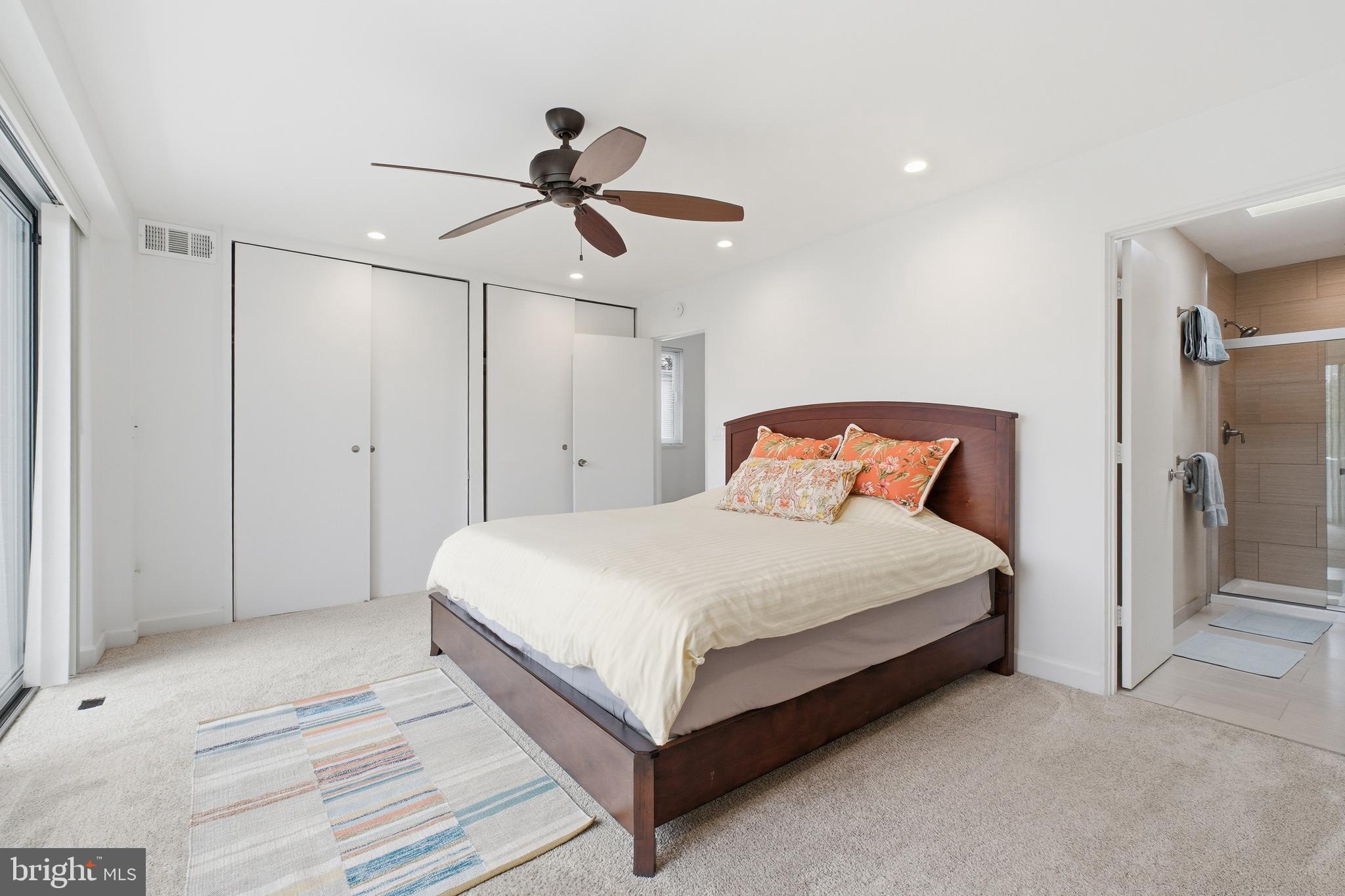 4848 Reservoir Road Northwest Washington, DC 20007 - Photo 17 of 49 a bedroom with a bed and a ceiling fan