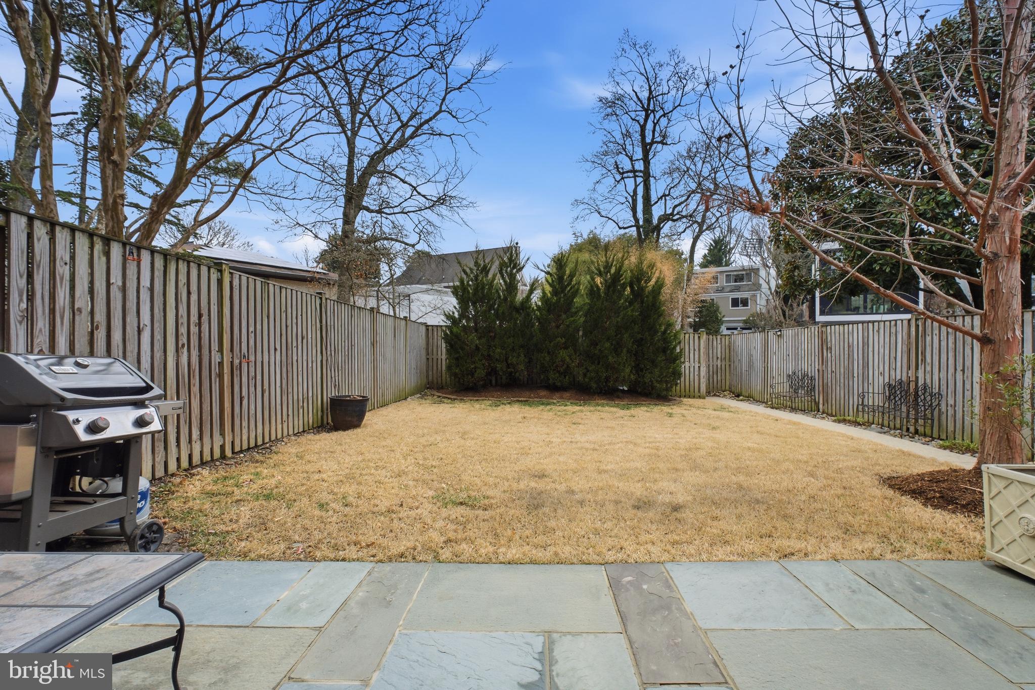 4848 Reservoir Road Northwest Washington, DC 20007 - Photo 38 of 49 a backyard of a house with a trees and wooden fence