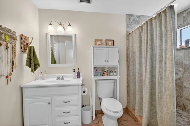 a bathroom with a toilet sink vanity and mirror