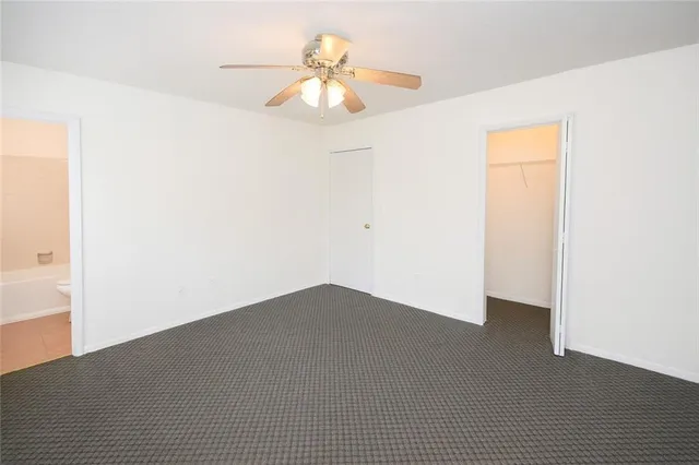 a view of a big room with closet and a chandelier fan