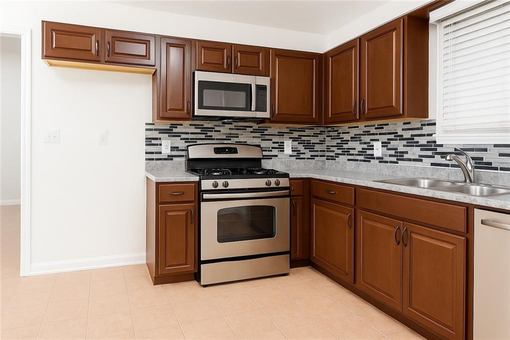 5328 Ridge Forest Drive Stone Mountain, GA 30083 - Photo 4 of 6 a kitchen with stainless steel appliances a stove microwave and sink