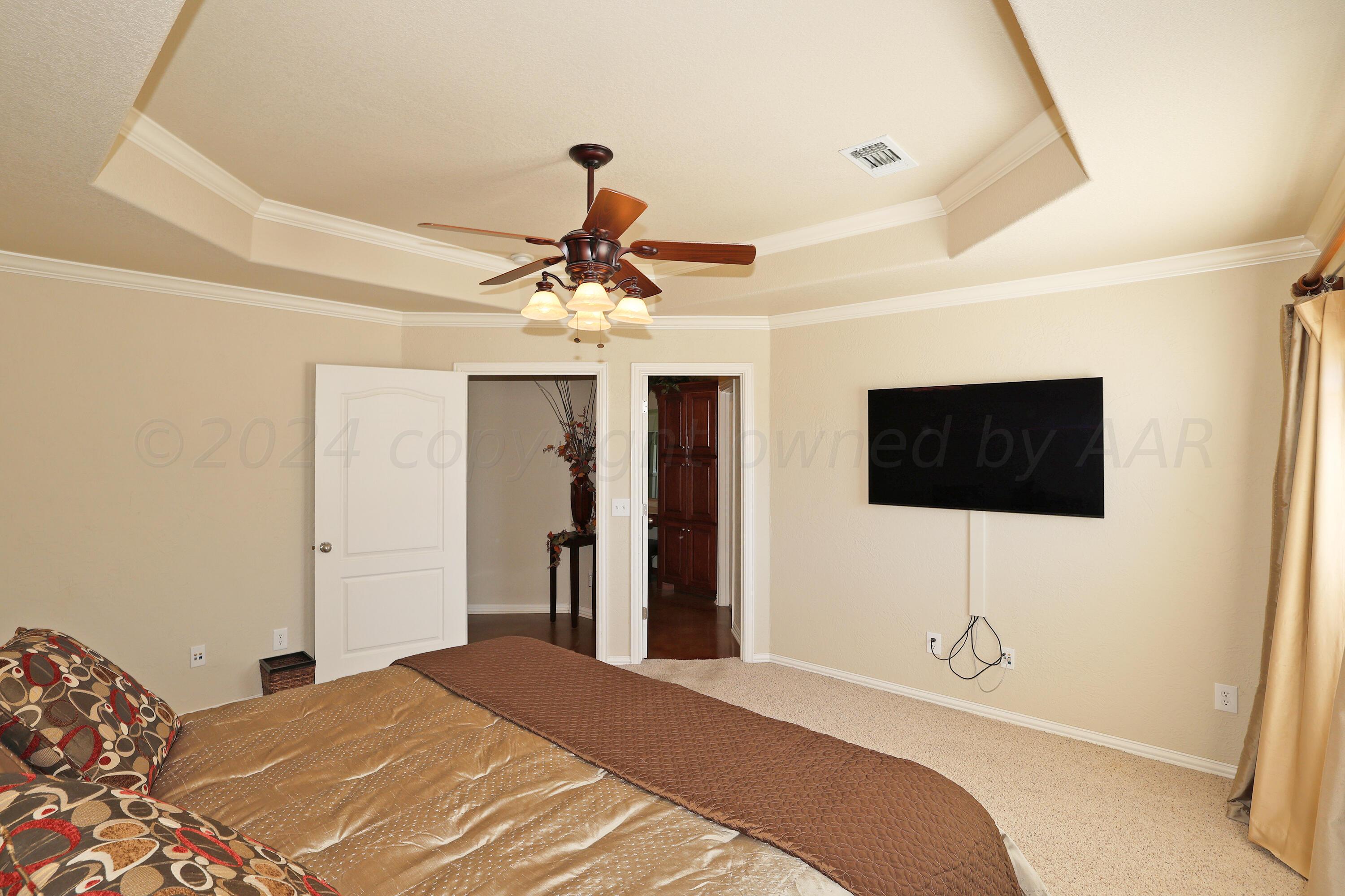 6902 Thunder Road Amarillo, TX 79119 - Photo 13 of 32 a bedroom with a bed and a flat screen tv