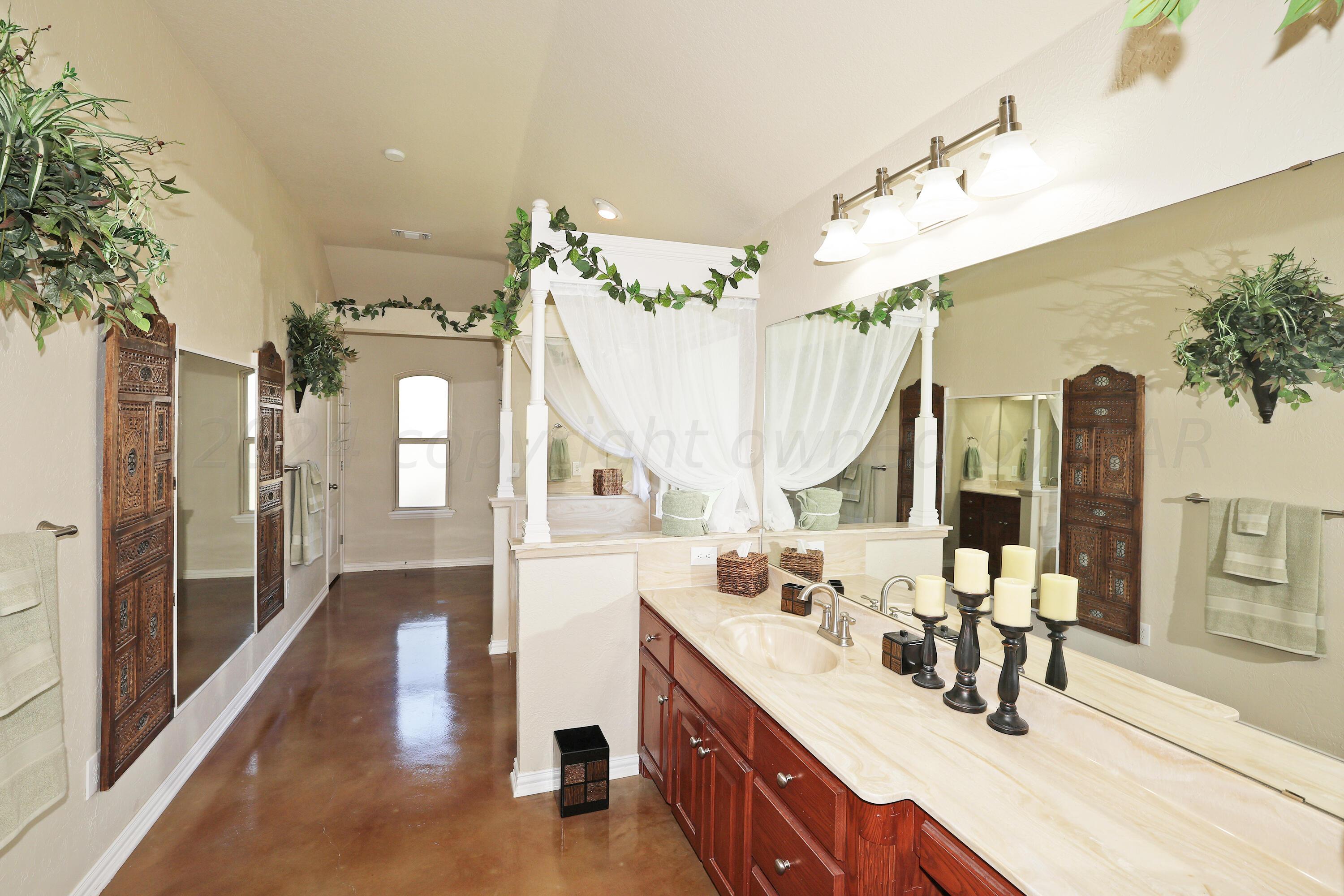 6902 Thunder Road Amarillo, TX 79119 - Photo 14 of 32 a bathroom with sink a mirror and vanity