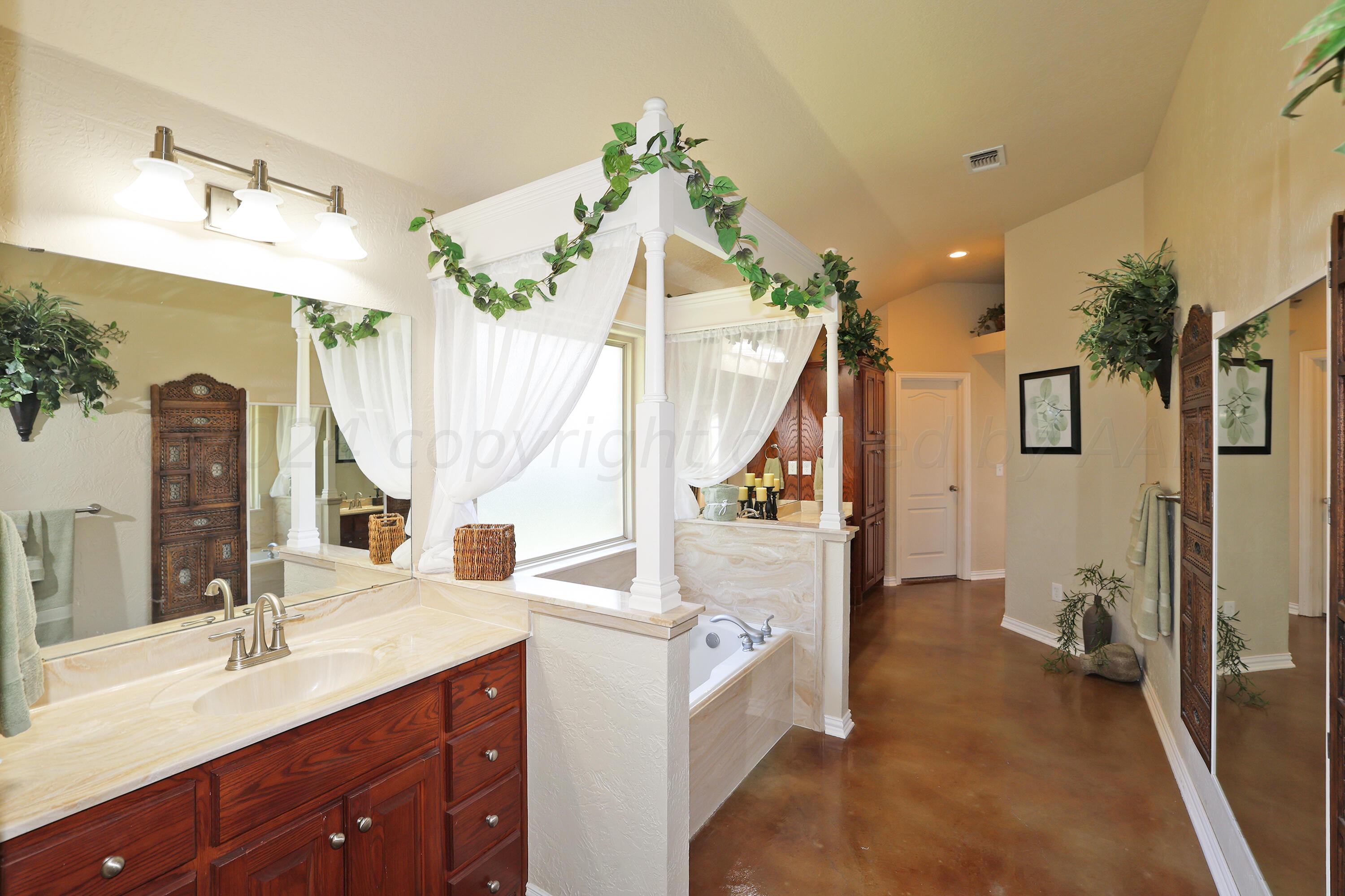 6902 Thunder Road Amarillo, TX 79119 - Photo 15 of 32 a en suite bathroom with a sink and a mirror