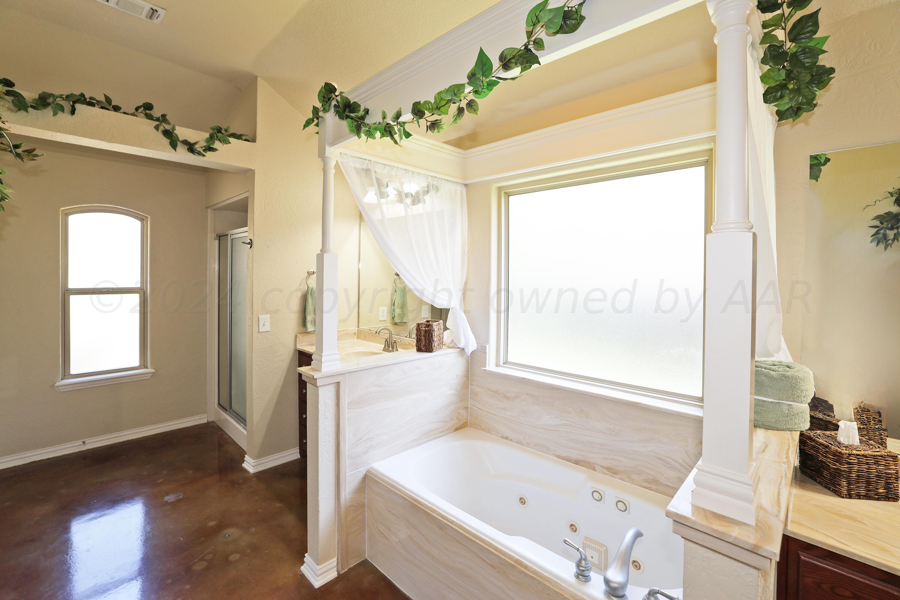 6902 Thunder Road Amarillo, TX 79119 - Photo 16 of 32 a bathroom with a tub sink and mirror