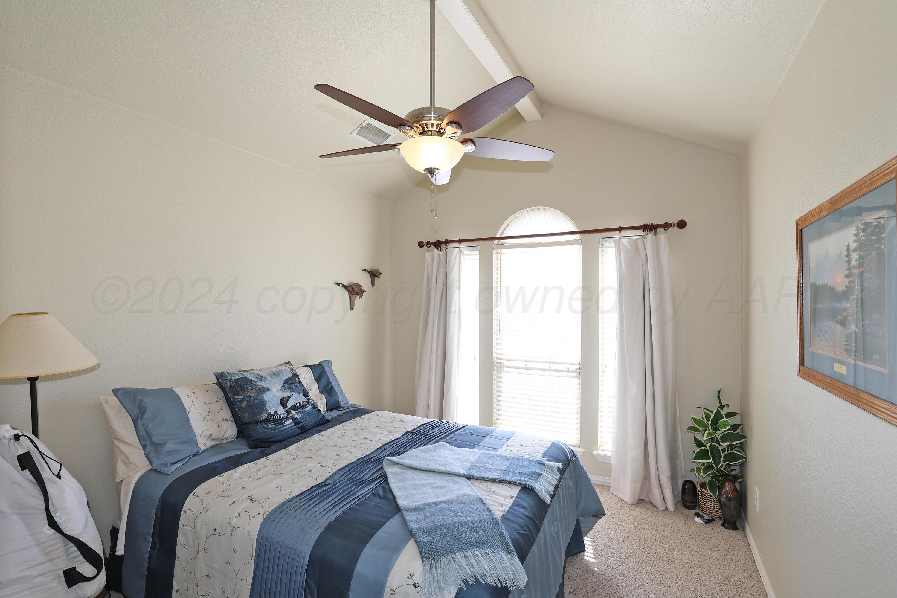 6902 Thunder Road Amarillo, TX 79119 - Photo 19 of 32 a bedroom with a bed and a chandelier