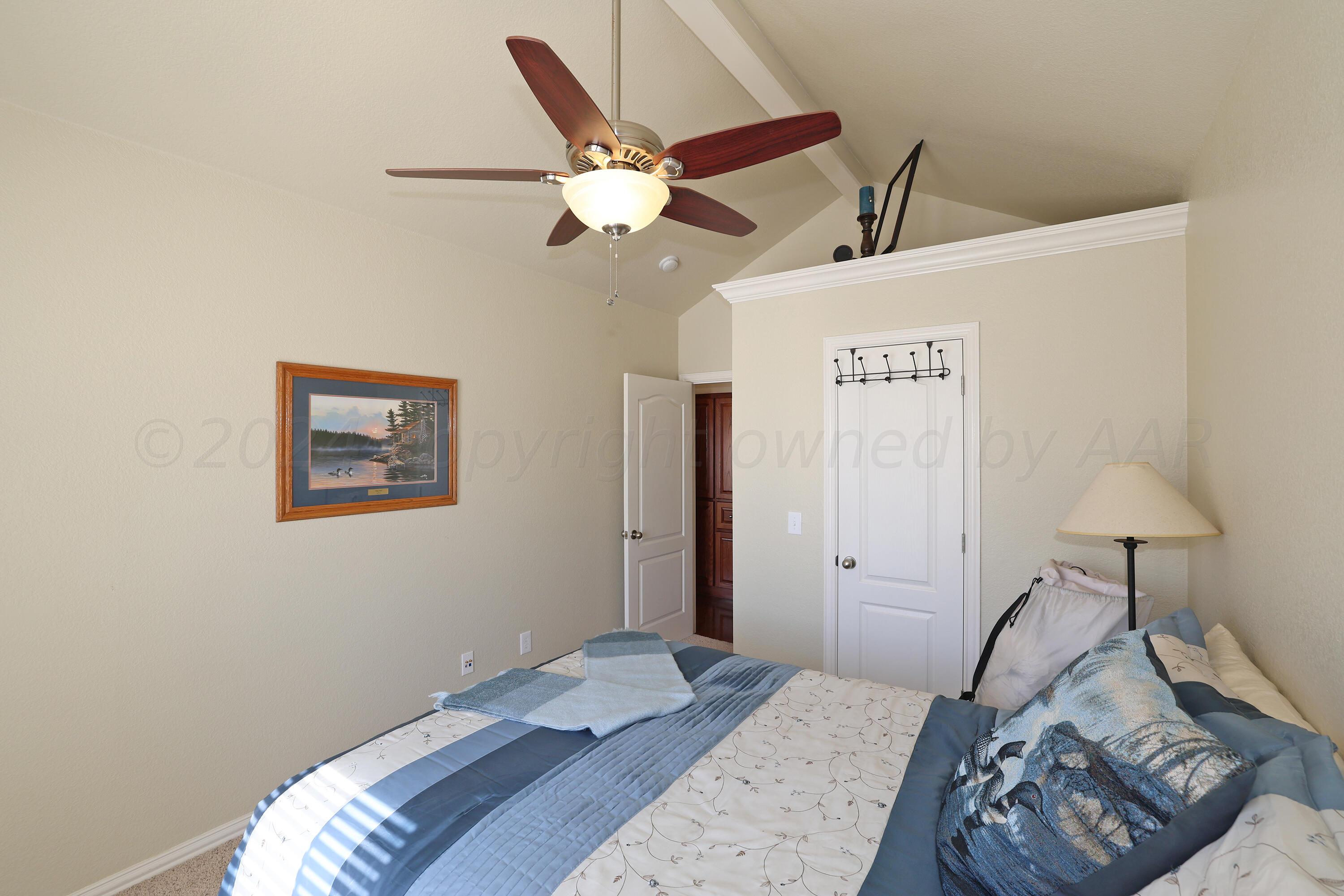 6902 Thunder Road Amarillo, TX 79119 - Photo 20 of 32 a bedroom with a bed and a chandelier