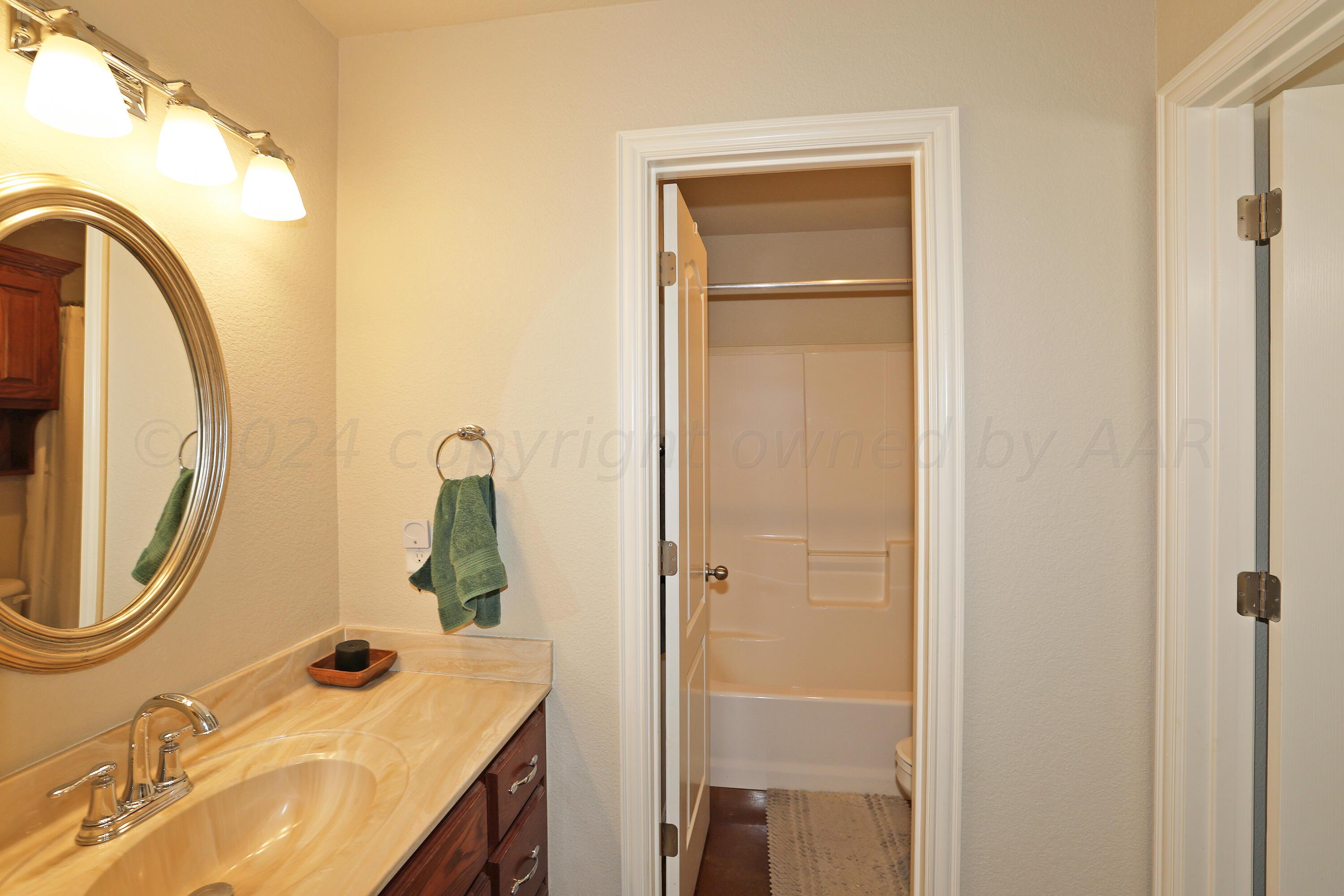 6902 Thunder Road Amarillo, TX 79119 - Photo 21 of 32 a bathroom with a sink vanity and a mirror
