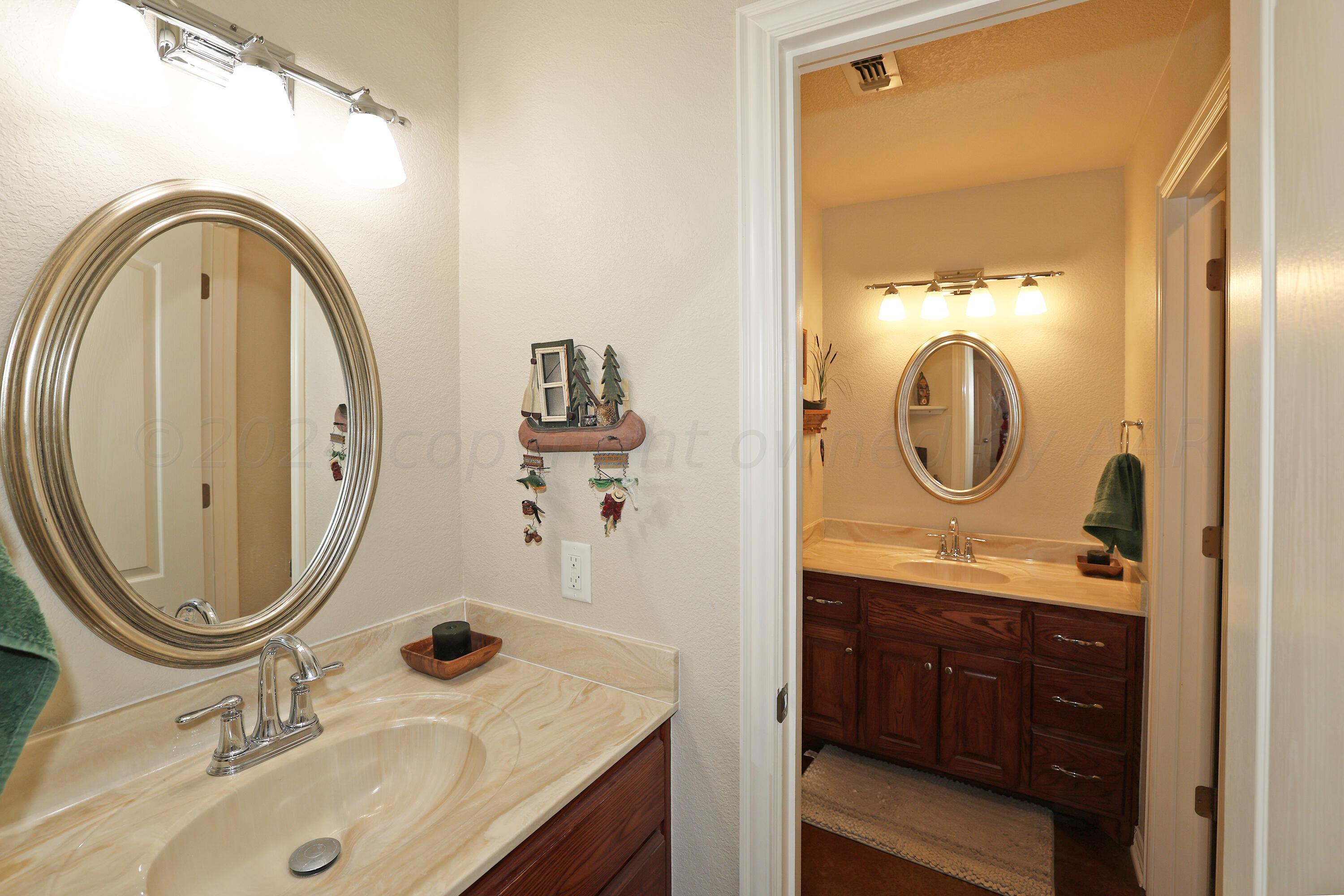 6902 Thunder Road Amarillo, TX 79119 - Photo 22 of 32 a bathroom with a sink and a mirror