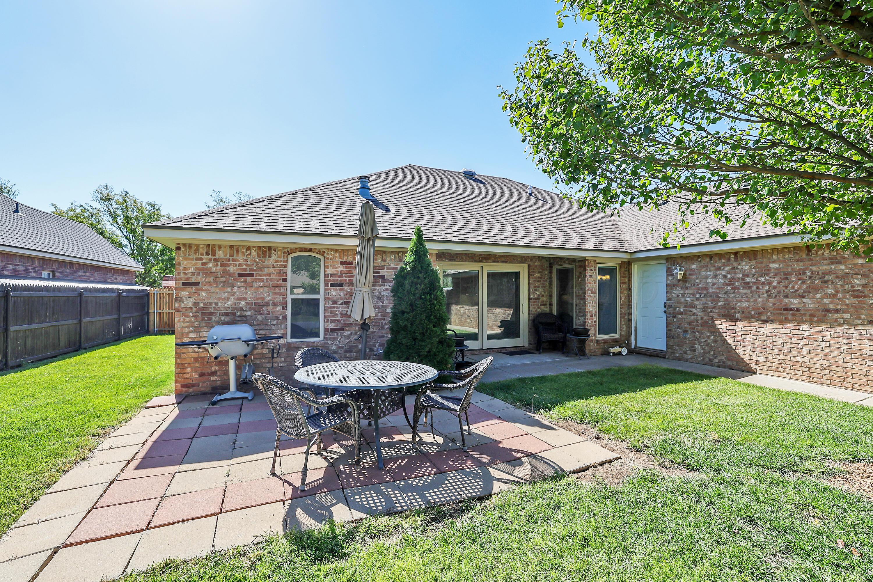 6902 Thunder Road Amarillo, TX 79119 - Photo 27 of 32 a view of a patio with table and chairs under an umbrella