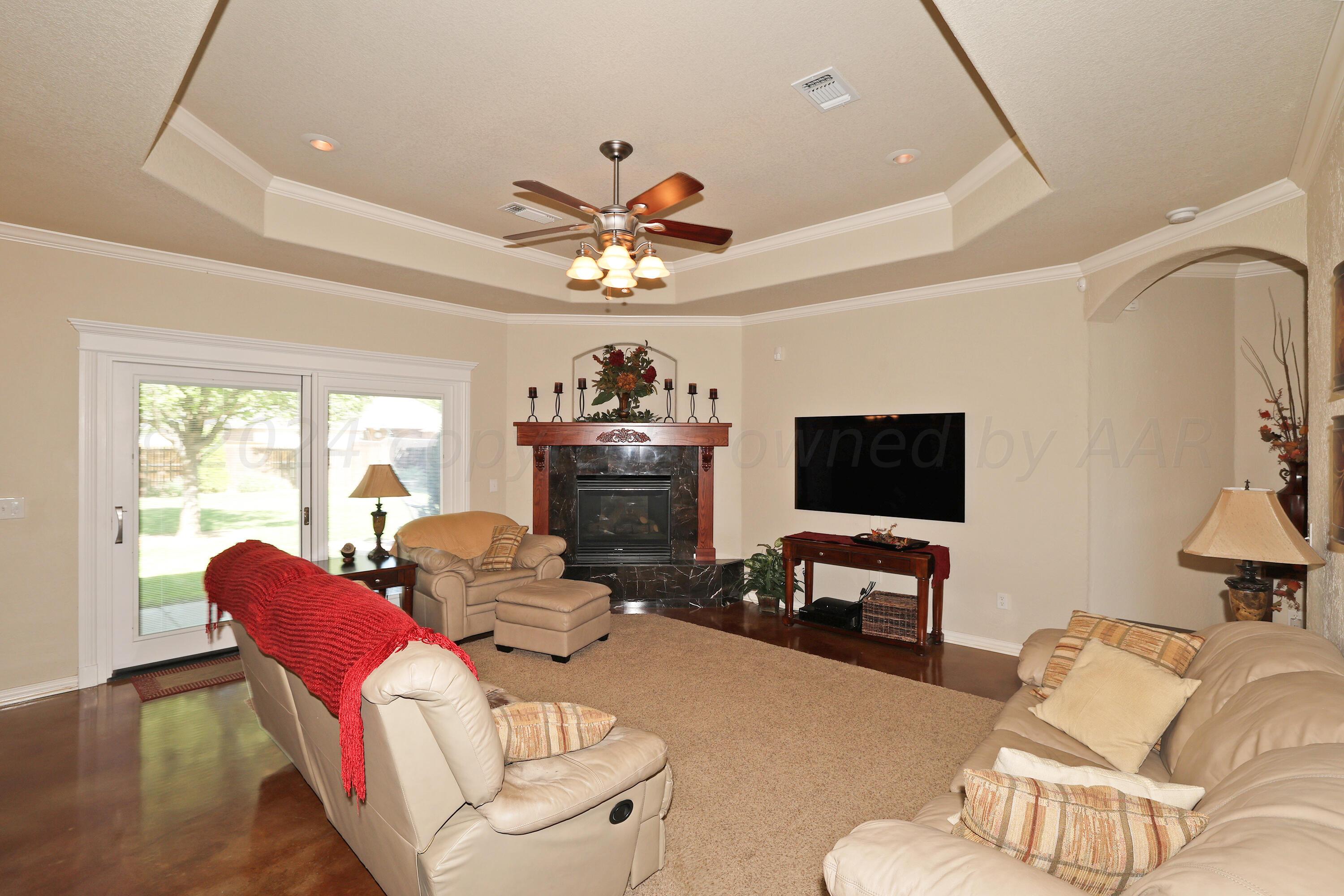 6902 Thunder Road Amarillo, TX 79119 - Photo 4 of 32 a living room with furniture a flat screen tv and a large window