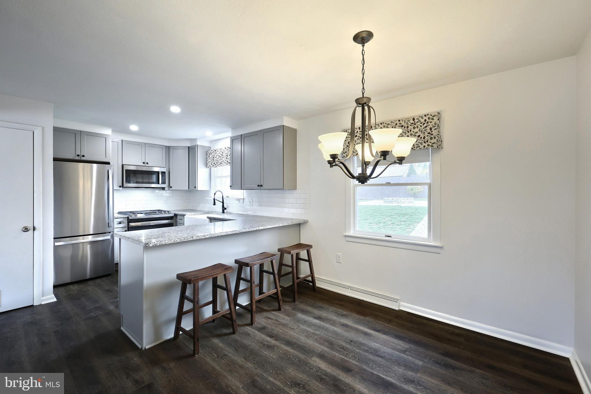 13 Circle Drive Jacobus, PA 17407 - Photo 6 of 53 a kitchen with stainless steel appliances granite countertop a stove refrigerator and a wooden floor