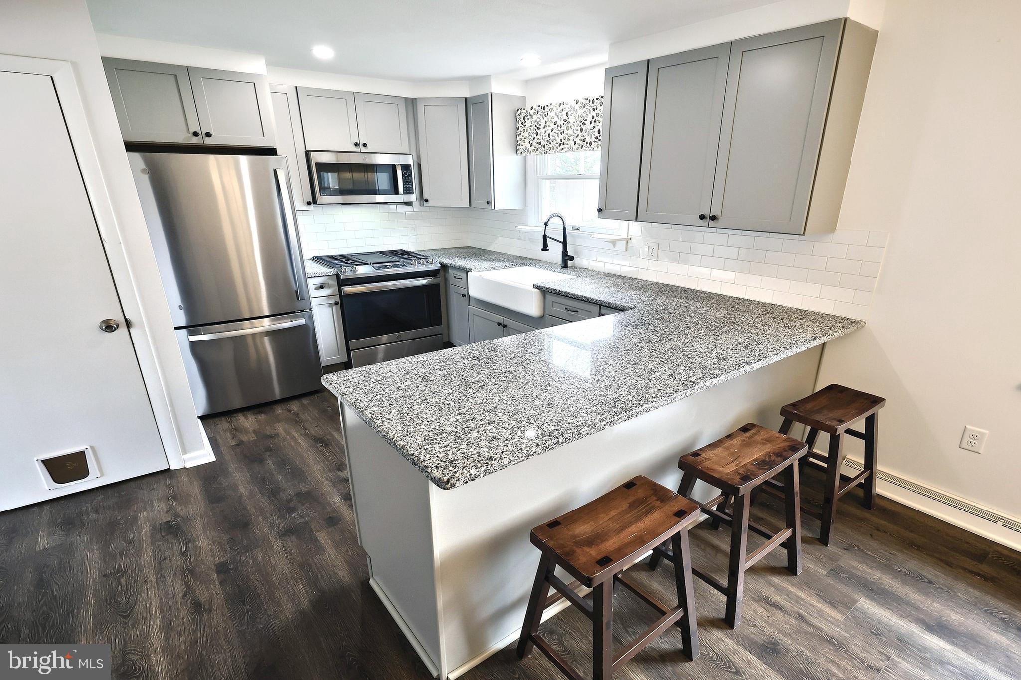 13 Circle Drive Jacobus, PA 17407 - Photo 7 of 53 a kitchen with granite countertop a table chairs microwave and refrigerator