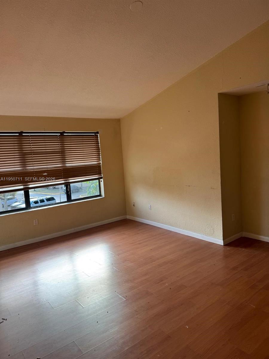 a view of a room with wooden floor and a window